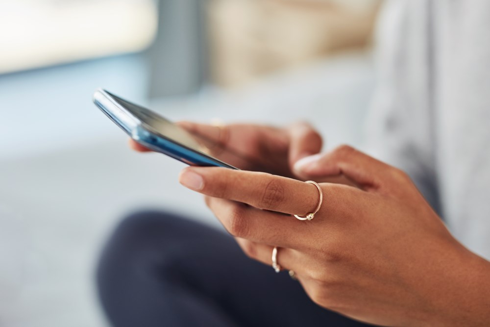 En kvinne som holder telefonen sin i hånda
